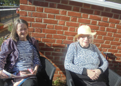 Two residents enjoying the sun in the garden at the Old Downs Residential Care Home