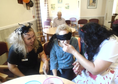 Residents and staff at The Old Downs Residential Care Home playing Halloween food tasting games