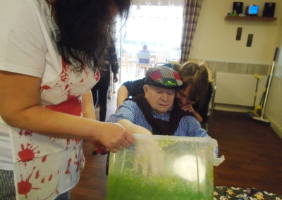 Residents and staff at The Old Downs Residential Care Home playing Halloween What can you find in the gloop game