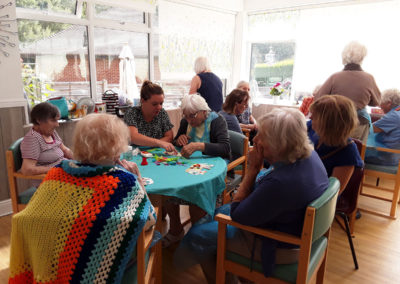 Residents around tables doing arts and crafts at The Old Downs Residential Care Home