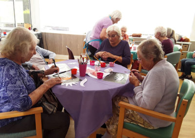 Residents at The Old Downs painting parts of a flamingo collage with Creative Mojo