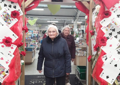 Lady residents at Millbrook Garden Centre standing by a deck of cards display