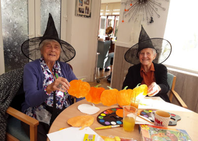 Two lady residents making pumpkin shapes bunting for Halloween