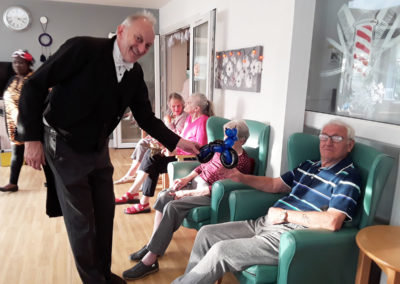 Magician singing with residents in their lounge at The Old Downs