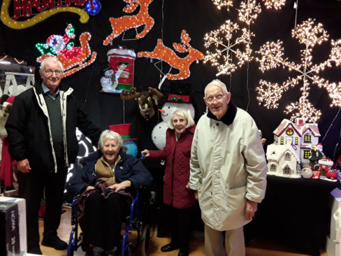 A group of residents and family members from The Old Downs by the Christmas lights in Hawley Garden Centre