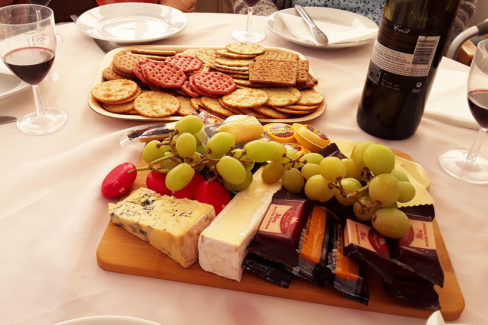 A table set with cheese board, crackers and wine