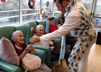 Elvis tribute singer giving a rose to a lady resident