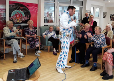 Elvis tribute singer performing to The Old Downs residents in their lounge