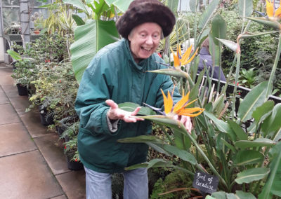 An Old Downs resident admiring a plant inside a tropical greenhouse at Hall Place