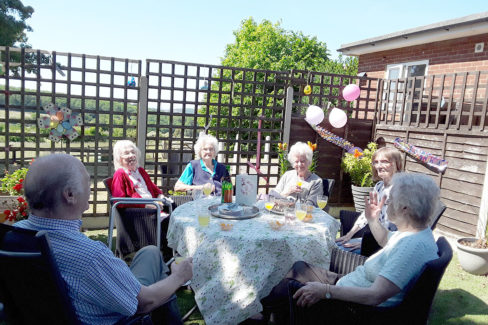 Residents enjoying a birthday afternoon tea in the garden at The Old Downs