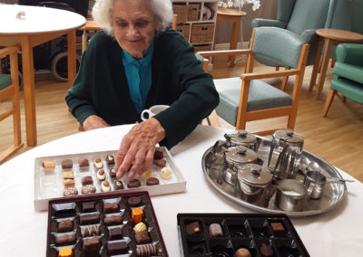 A lady resident from The Old Downs choosing a chocolate to taste
