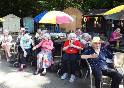 Residents enjoying ice lollies in the garden at The Old Downs Residential Care Home
