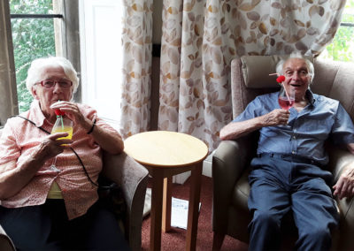 Two residents in the lounge drinking Prosecco cocktails at The Old Downs