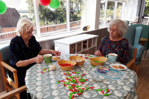 Residents making Italian themed pasta necklaces at The Old Downs