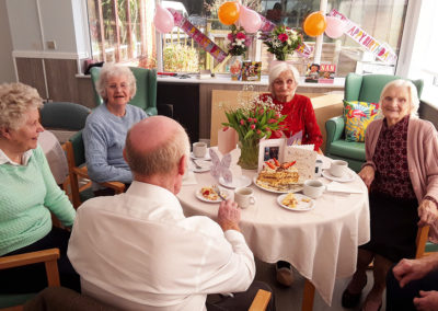 Edna enjoying a birthday tea party with friends at The Old Downs Residential Care Home