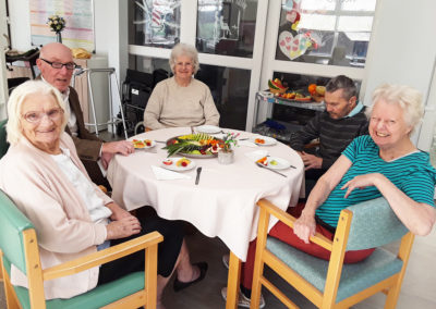 The Old Downs Residential Care Home residents enjoying fruit tasting around a table together