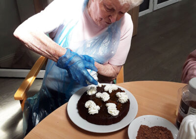 Cake decorating with squirt cream at The Old Downs Residential Care Home