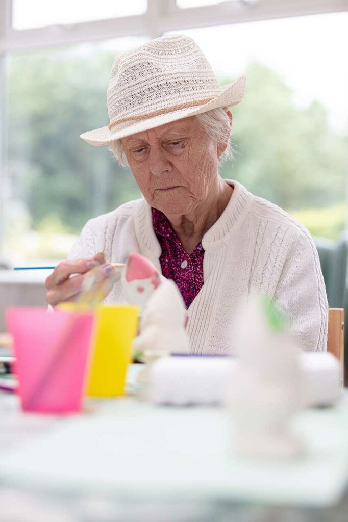 A resident at The Old Downs Residential Care Home enjoying an arts and crafts activity