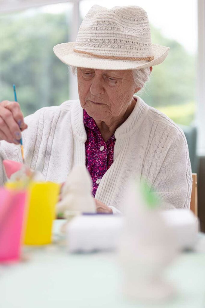 A resident at The Old Downs Residential Care Home enjoying an arts and crafts activity