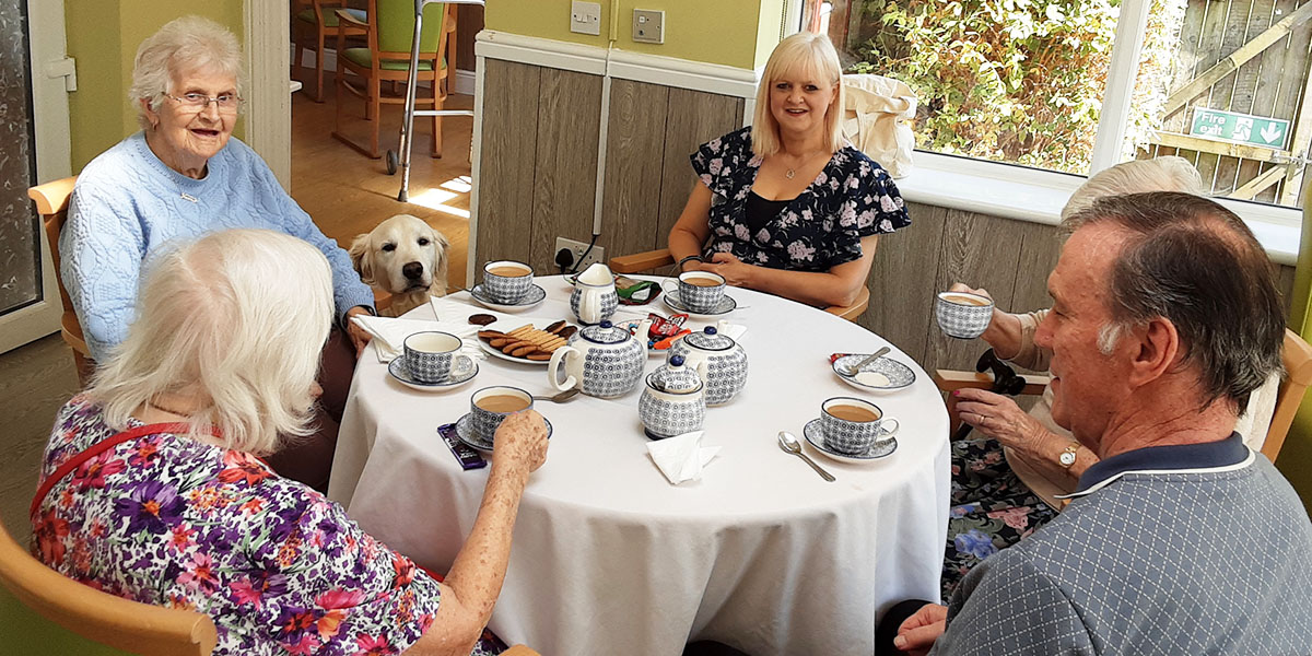 The Old Downs Residential Care Home residents enjoying tea and biscuits with Barney