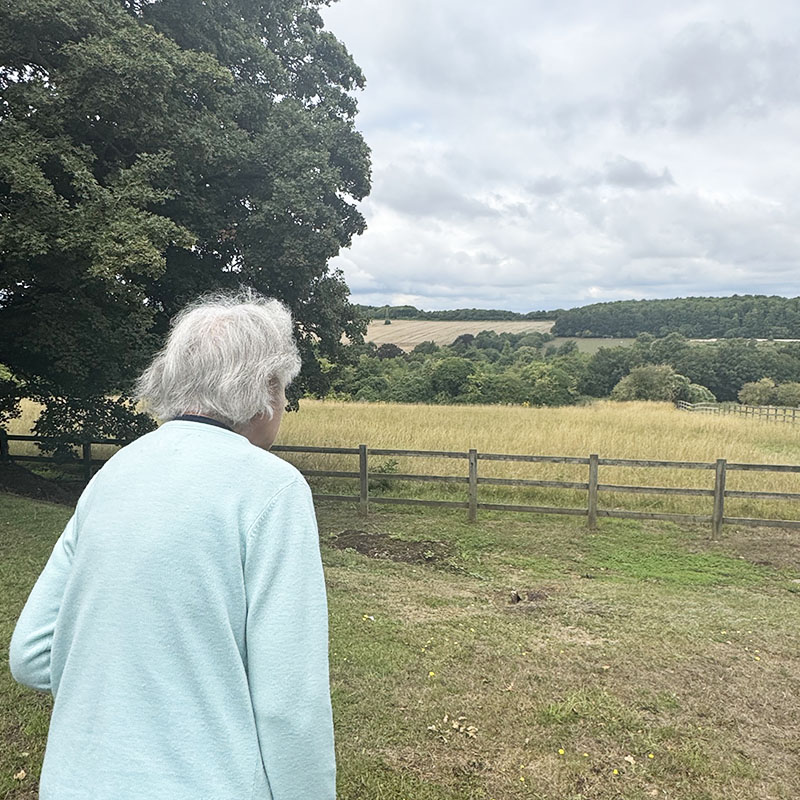 The Old Downs Residential Care Home lady resident enjoying a stroll outside to admire the country view