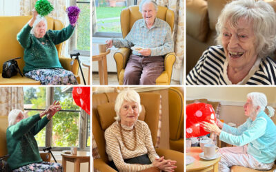 Residents at The Old Downs Residential Care Home enjoying a fun seated exercise class with instructor Rosie, featuring stretching and games with an inflatable dice.