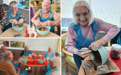 The Old Downs Residential Care Home residents adding eggs and preparing a chocolate brownie mix together around a table.