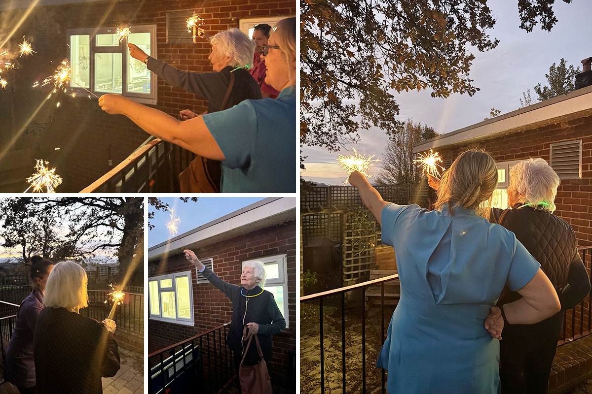 Residents at The Old Downs Residential Care Home enjoying the Bonfire Night celebrations outdoors with sparklers in hand as evening falls.