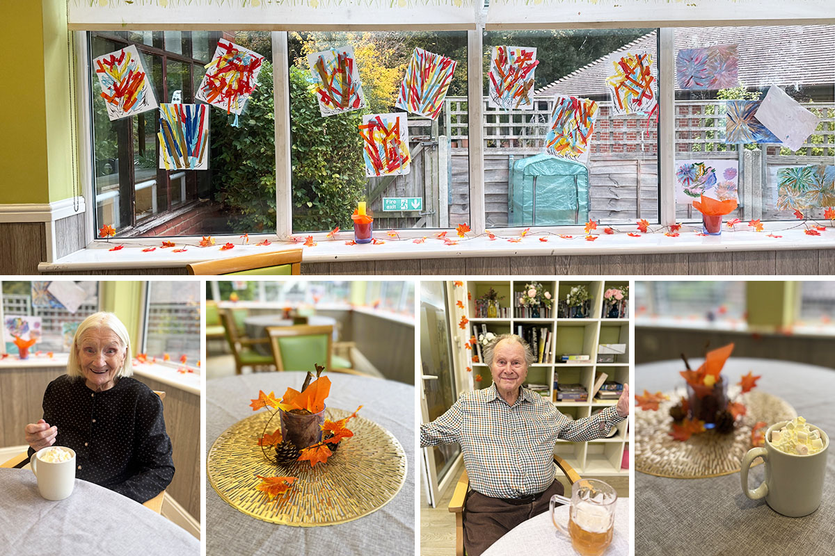 The dining area at The Old Downs Residential Care Home decorated with residents’ firework art and autumn-themed table centrepieces, with residents enjoying hot chocolate and drinks.